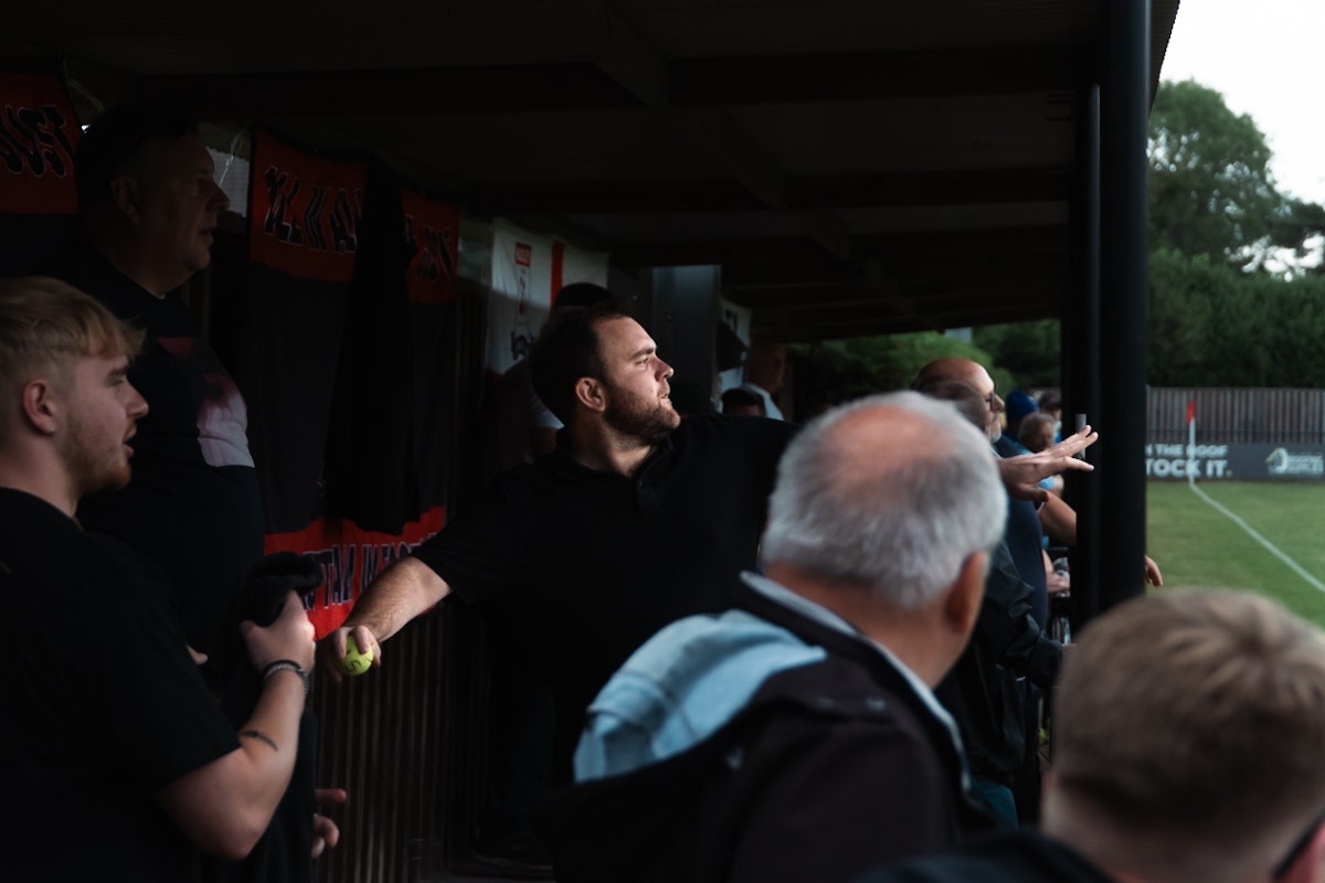 A fan throwing getting ready to throw a tennis ball in the Hadley FC Half-Time Tennis Ball Throwing Competition at Brickfield Lane