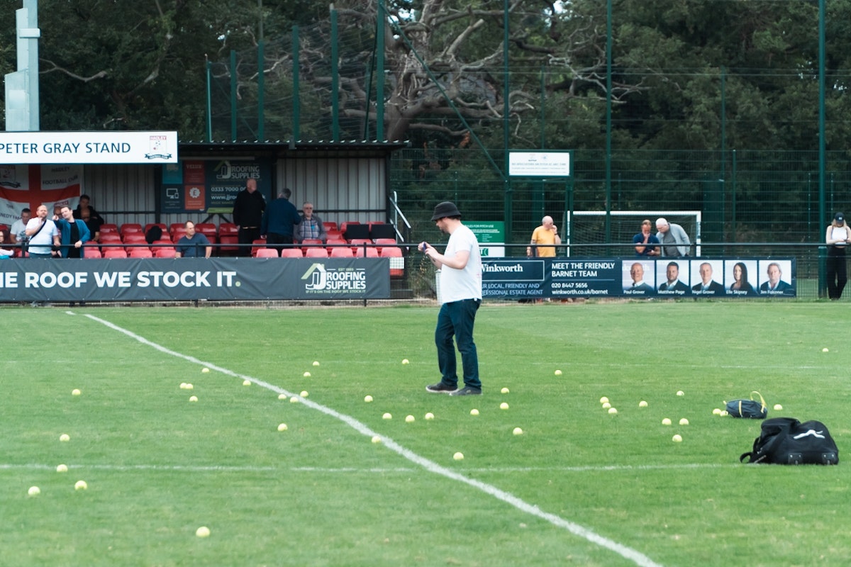 Tennis balls all over the pitch in the Hadley FC Half-Time Tennis Ball Throwing Competition at Brickfield Lane